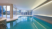 Large indoor freeform pool with wall of windows