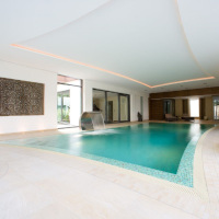 Large indoor pool with curved sides and pool shape reflected on ceiling