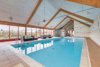Rectangle indoor pool with white wood pool hall roof