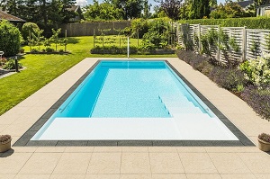 Rectangle pool with contrast created by dark coping stones and limestone paving