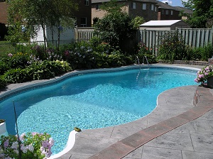 Outdoor freeboard shotcrete pool with curved plan walls and freize