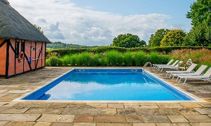Freeboard vinyl liner pool with limestone slab paving